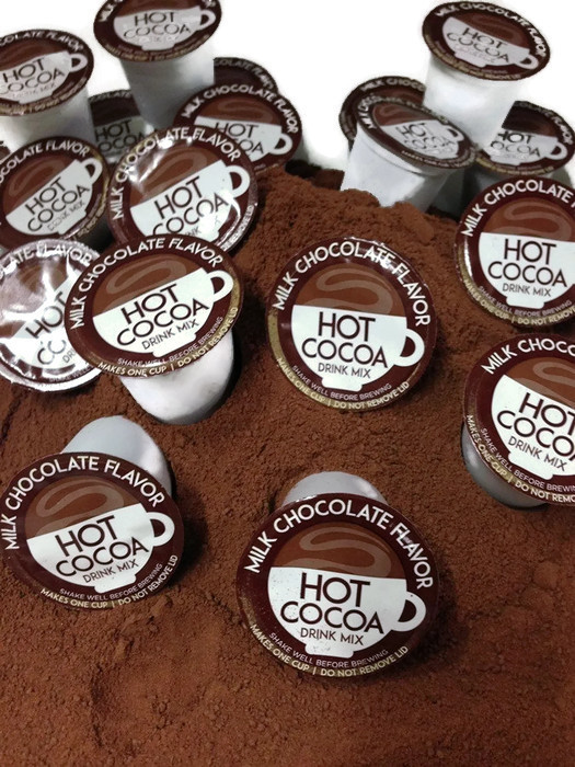 hot chocolate single service pods sitting in pile of cocoa